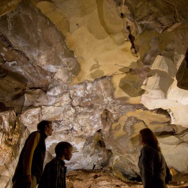 family of three examining the natural beauty of the cave